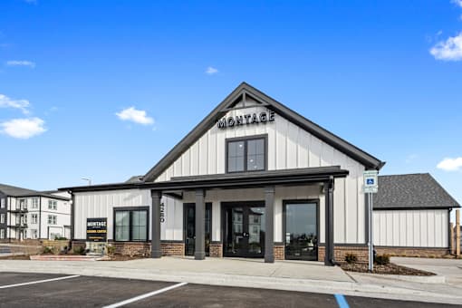 Leasing center exterior at Montage West Lafayette featuring modern farmhouse architecture, branded signage, and convenient parking.
