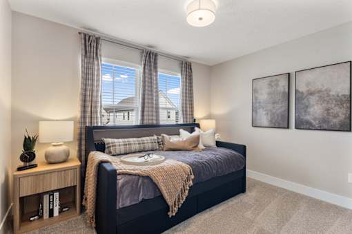 Comfortable apartment bedroom at Mural Lewis Center featuring large windows with natural light, plush bedding, neutral color palette, ceiling light fixture, and modern decor