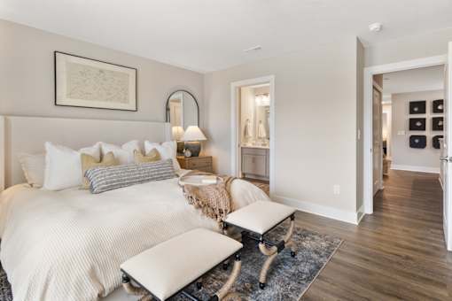 Elegant apartment living room at Mural Lewis Center featuring neutral tones, cozy seating, accent chairs, wood-style flooring, modern decor, and bright natural light
