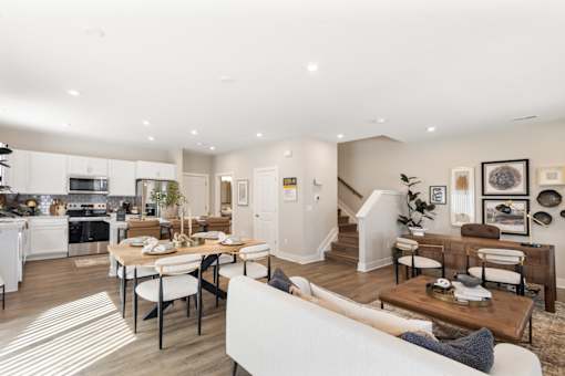 Spacious open-concept kitchen and living area in single-family rental home at Mural Lewis Center featuring large island, wood-style flooring, modern furnishings, and seamless flow between spaces