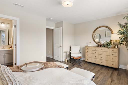 Bedroom with bed, nightstands, and natural light from large windows at Mural Lewis Center
