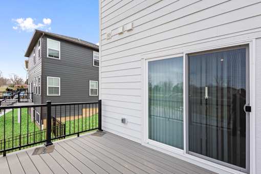 Rear view of rental home featuring elevated deck and sliding glass doors at Mural Lewis Center in Lewis Center, Ohio