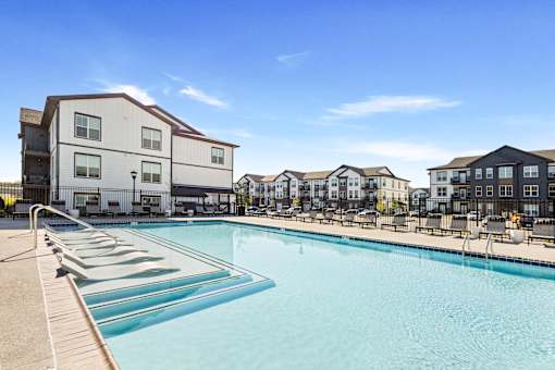 A swimming pool in front of apartment buildings.