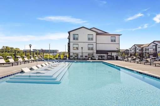Outdoor swimming pool with tanning ledge and clubhouse view at Nook Nine
