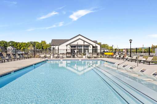 A sparkling resort-inspired pool surrounded by lounge chairs and umbrellas, offering residents a relaxing outdoor retreat  at Montage West Lafayette Apartments, West Lafayette, Indiana