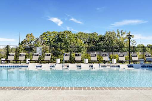 Comfortable poolside loungers line the modern swimming pool area at Montage West Lafayette, perfect for sunbathing and enjoying the Indiana summer. at Montage West Lafayette Apartments, West Lafayette