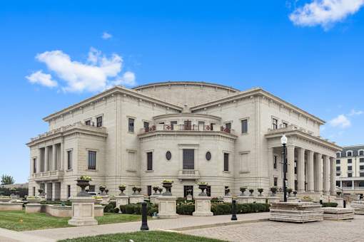 a large white building with columns and a dome with a blue sky in the background at Gramercy Apartments, Indiana