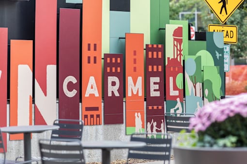 a sign for a restaurant with a city skyline on it at Gramercy Apartments, Carmel Indiana