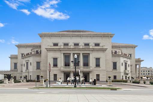 a large white building with people standing in front of it at Gramercy Apartments, Carmel, 46032