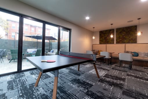 a games room with a ping pong table and a patio at 310 at Nulu Apartments-Student, Louisville, KY