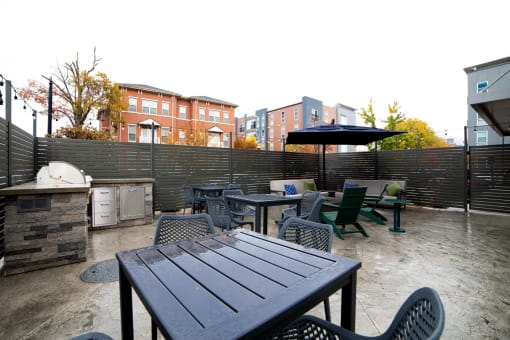 a patio with tables and chairs and a grill at 310 at Nulu Apartments-Student, Louisville