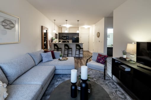 a living room and kitchen with a couch and a table at 310 at Nulu Apartments-Student, Louisville, 40202