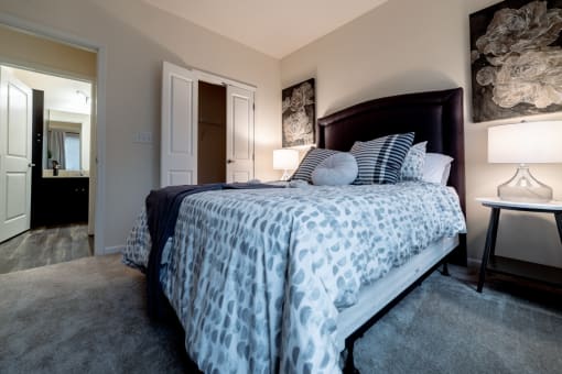 a bedroom with a large bed and a bathroom at 310 at Nulu Apartments-Student, Louisville, KY