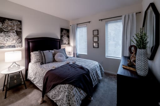 bedroom with a large bed and a dresser with a potted plant at 310 at Nulu Apartments-Student, Louisville, KY 40202