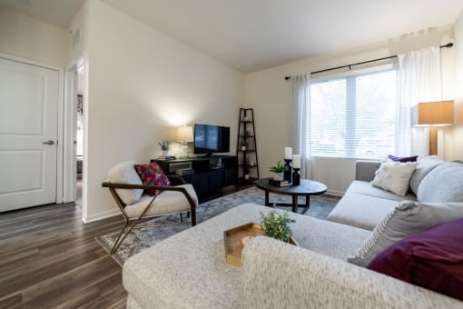 an apartment living room with couches and a tv at 310 at Nulu Apartments-Student, Louisville, 40202