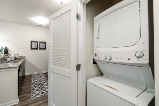 a washer and dryer in a laundry room with a sink and a door at 310 at Nulu Apartments-Student, Kentucky