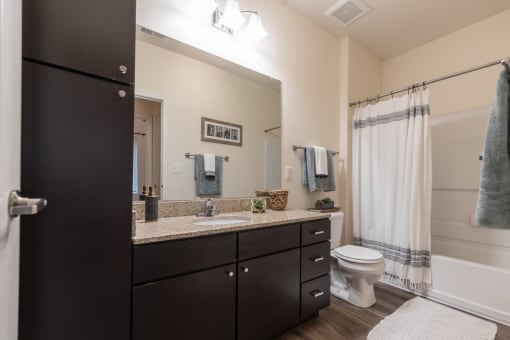 an open bathroom with a large mirror and a toilet and sink at 310 at Nulu Apartments-Student, Louisville