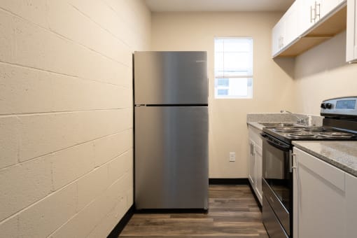 a kitchen with a refrigerator and stove and a window