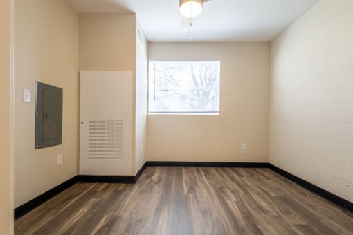 an empty room with wood floors and a window