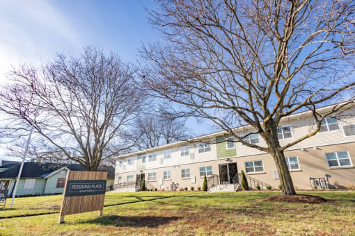 an apartment building with a sign in front of it