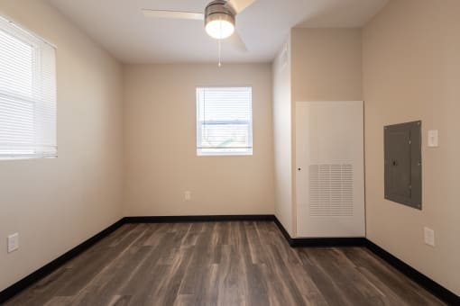 an empty living room with a door and a window