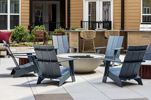Cozy outdoor fire pit area with modern lounge seating at Portrait Midtown apartments.
