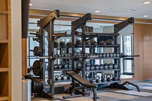Modern fitness center at Portrait Midtown featuring a variety of weightlifting machines and free weights.
