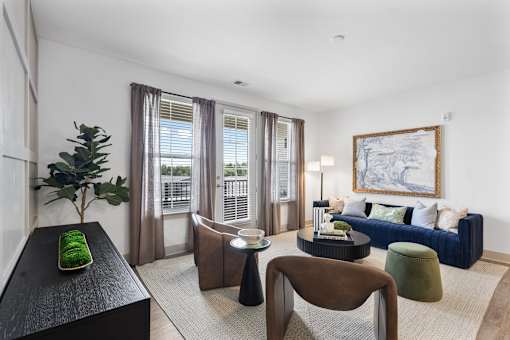Sunlit apartment living room featuring beautiful hardwood-style flooring, a spacious layout for furniture, and large glass sliding doors that open up to a private balcony.