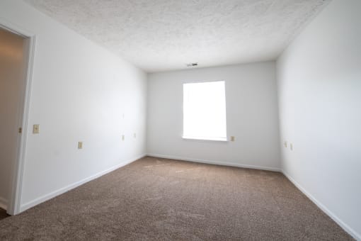 a large empty room with white walls and carpet