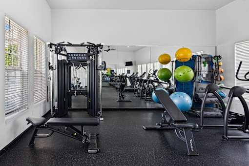 24-hour fitness center featuring strength training equipment, free weights, adjustable benches, cardio machines, and functional fitness equipment at Steeplechase at Shiloh Crossing Apartments in Avon, Indiana.