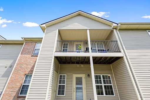 Apartment building featuring private patios and covered balconies, offering outdoor living space at Steeplechase at Shiloh Crossing Apartments in Avon, Indiana.