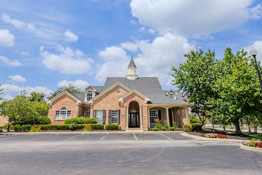 Beautifully landscaped leasing office and community entrance featuring classic brick architecture at Steeplechase at Shiloh Crossing Apartments in Avon, Indiana.