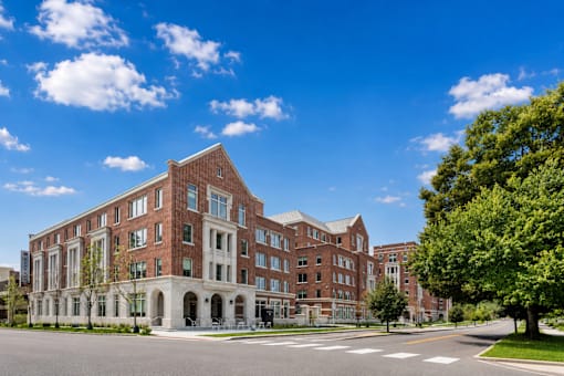 A large red brick building with white trim and a tree in front.
