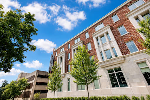 A red brick building with a parking garage behind it.