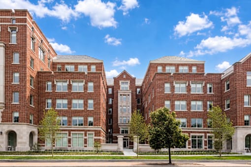 A large red brick building with a tree in front.