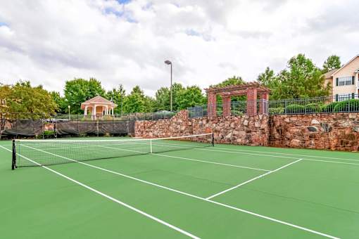 Outdoor tennis court with scenic landscaping and community amenities at Village at Almand Creek apartments in Conyers, GA. Perfect for recreation and active living.