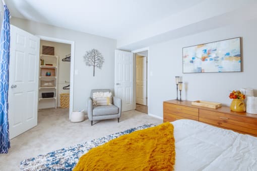 a bedroom with a bed and a chair and a closet