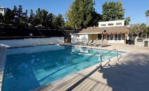 The recreational area where there is a square pool behind the leasing office building.