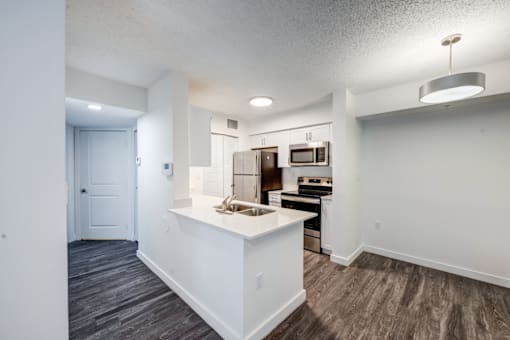 A kitchen with a white island and stainless steel appliances.