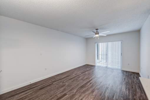 A room with wooden flooring and a ceiling fan.