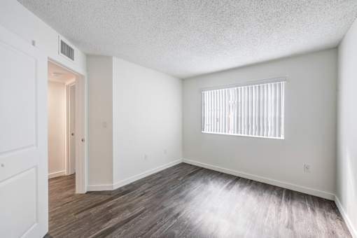 A room with a window and wooden flooring.