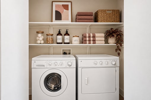 Two white front loading washing machines in a laundry room.
