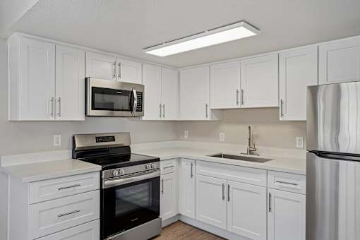 Modern kitchen with white cabinets and stainless steel appliances at Dash Apartments, Las Vegas, NV