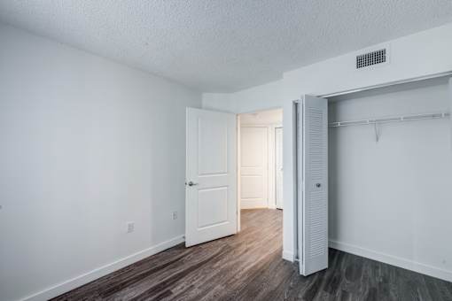 A white room with a door and a closet.