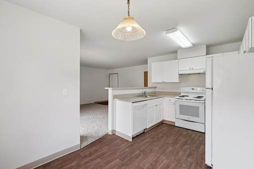 A kitchen with white cabinets and a white stove.