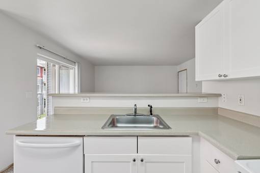 A kitchen with white cabinets and a sink.