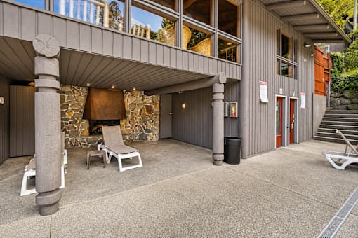 A modern building with a stone fireplace and a covered outdoor seating area.