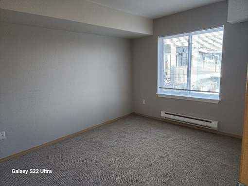 A room with a window and a wall-mounted air conditioner.
