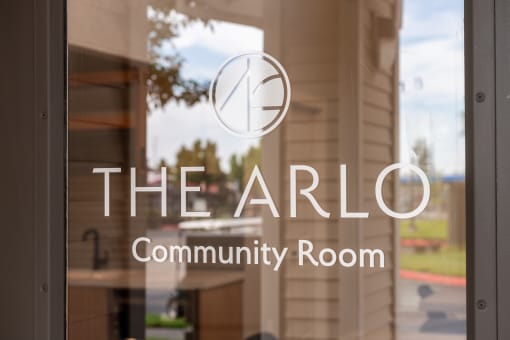 the arlo community room logo on a glass door