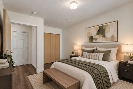 A bedroom with a bed, nightstands, and a painting on the wall.